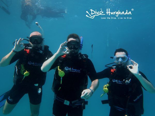 Happy divers underwater scuba diving with Dive Hurghada team